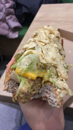 Mexican hot dog! Lettuce, tofu sausage, cheese, guac, sauce, crumbled tortilla chips  at Vegan Love in Budapest