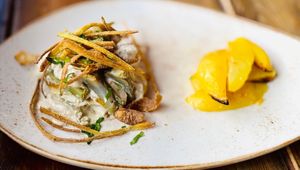Marinated chickpea tempeh with artichokes, cashew homemade cream and chips of Jerusalem artichokes, served with baked potatoes at Rifugio Romano in Rome