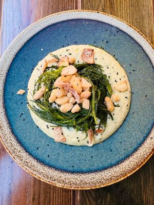 Agretti (spring veg) sautéed with garlic, oil, and chili on a protein cream of cannellini beans, potatoes, and tahini, with Jerusalem artichoke chips at Rifugio Romano in Rome