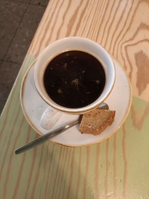 Coffee served with a chunk of banana bread! at PLUS in Ghent