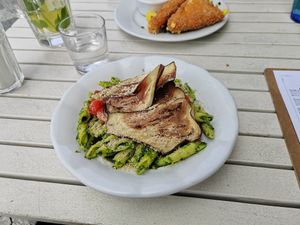 Penne pasta with pea and rocket pesto, cherry tomatoes and aubergine bacon. at Herbivore in Prague