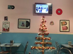 Old TV shows and commercials are show in their original black and white on a new tv made to look like an old tv. Christmas tree because it is the season right now. at Comet 984 in Playa Del Carmen