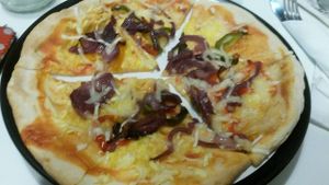 Onion and pepper pizza with vegan cheese at Roots Cafe in South Shields