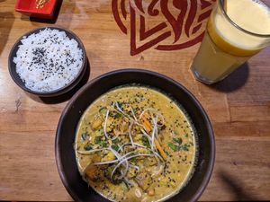 Red coconut curry, rice and passion fruit juice. at The Vegan Temple by Prasada in Cusco