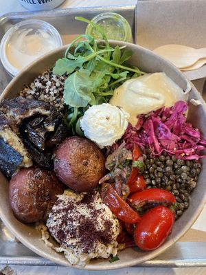 Eggplant seared on a hot grill, creamy baba ganoush, almond feta, smashing potatoes, pomegranate-infused tomatoes, black lentils, quinoa, greens.  at Shouk in Washington