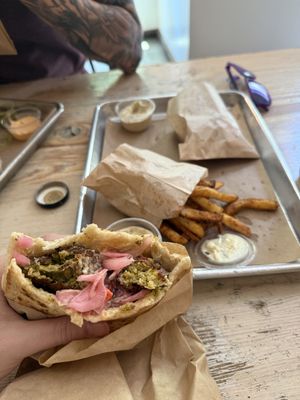 Fancy falafel in a pita with spice fries and shouk saucee  at Shouk in Washington