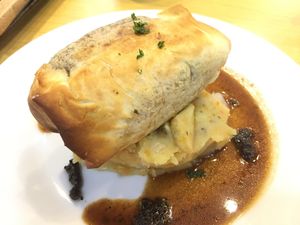 Baked filo pastry in Wellington style with carrot and potato mash, vegan truffle gravy at Veggle Cafe in Kowloon
