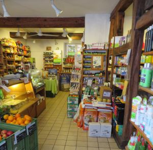 counter with cakes, bread, and cheese, bulk food, cleaning products, candles, etc. at Mutter Erde Naturkost in Saarbrucken
