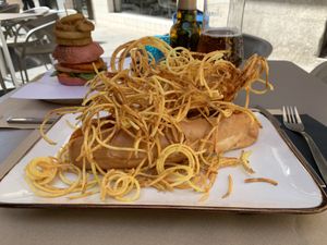 Perrito de Beyond Meat con sabrosa salsa picante, champiñones… bajo una montaña de patatas crujientes at 269 Gastro Vegan in Salamanca