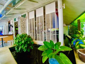 Outdoor patio with a fish pond. at Greenlight Cafe & Bar in Koh Samui