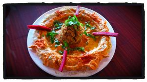 Sun dried tomato hummus with a baked falafel on top. at HANDHELDZ in Bethlehem