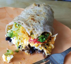 My burrito with daiya, black beans, rice, pineapple salsa, tofu adobo, avocado, sweet potato, red peppers, lettuce, and corn at Home Kitchen Cafe in Rockland