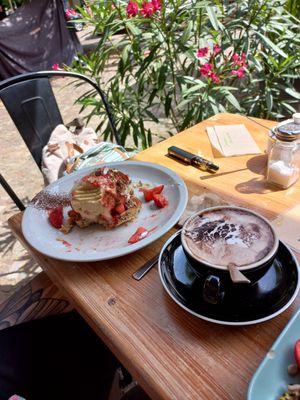 Hot chocolate and partially eaten waffle 🙃 at Cafe Neue Liebe in Berlin