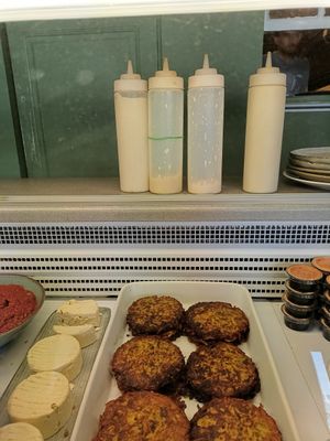 The sauce in the bottle with the green ribbon is vegan at Falafel Factory in Copenhagen