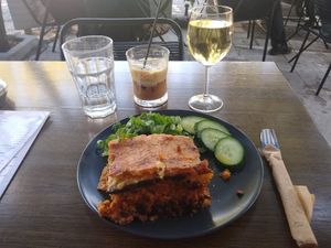Moussaka, salad & cucumbers, organic white wine and coconut freddo cappuccino at Veganaki in Athens