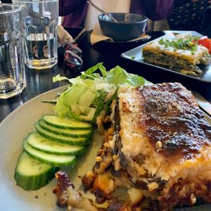 Huge portion of moussaka with smooth, creamy almond-milk béchamel and a side of cucumbers and dressed salad. at Veganaki in Athens