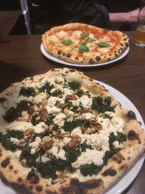 Pizza spinaci bianca and salami pizza in the background  at La Stella Nera in Berlin