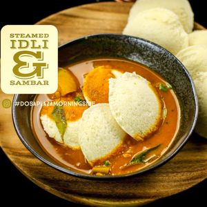 The Steamed Idli is a quintessentially South Indian savoury steamed rice dumpling dish, found across the globe. Made of a combination of rice and white lentil, soaked in water and ground separately to different consistencies and mixed together to form a lush batter and then fermented overnight. This batter is then steamed into wholesome disks that are best relished with our lentil-based vegetable stew (the Sambar) and/or our delicious ground coconut chutney. Vegan and gluten-free to boot!  at Dosa Plaza in Morningside