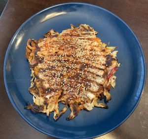 A cabbage & onion pancake with fried tofu, topped with house tonkatsu sauce, veganaise, house furikake, shichimi. house kimchi. at Obon Shokudo in Portland