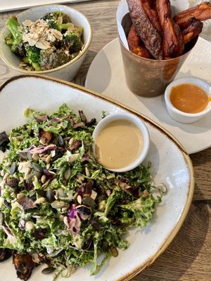 Sweet potato fries, shredded kale salad, charred almond butter broccoli  at Farmacy in West London