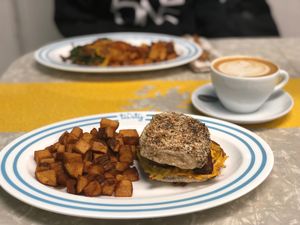 vegan bacon egg and cheese on a philly muffin with a side of home fries and an oat milk latte! at The Tasty in Philadelphia