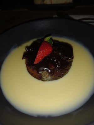 Sticky Toffee Pudding with Custard & a Strawberry. at Super Natural Newcastle in Newcastle Upon Tyne