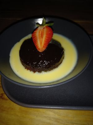 Sticky Toffee Pudding with Custard & a strawberry. at Super Natural Newcastle in Newcastle Upon Tyne