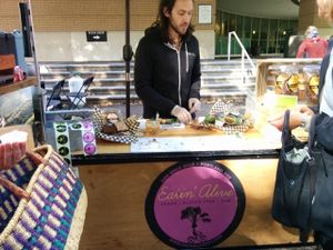 Friendly, knowledgeable staff at Eatin Alive's farmers market booth, offering samples of their delicious goodies at Eatin' Alive in Portland
