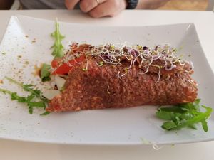 I don't remember the name, but the dough is like a pancake with lots of grains and inside hummus + salad at Rawdia in Brasov