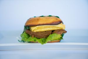 Gluten Free Sausage + Just Egg Sandwich made from Beyond Meat sausage patty, vegan cheese, vegan Just Egg, BLT sauce, and seasonal greens on toasted gluten-free bread at Glowing Plant Based Eatery in Los Angeles