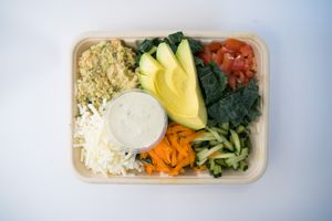 Creamy Kale Salad made from chickpea tuna, kale, seasonal greens, vegan cheese, cucumber, carrot, tomato, avocado and our creamy basil aioli (contains nuts) at Glowing Plant Based Eatery in Los Angeles