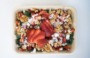 California Salad made from kale, strawberries (if in season, otherwise blueberries), vegan feta, sundried tomato, walnut, tomato, red onion, chickpea, garlic, olive oil and salt at Glowing Plant Based Eatery in Los Angeles