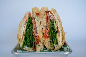 Italian Sandwich with vegan salami, cheese, spinach, sundried tomato, onion, bell pepper, olive, cucumber, tomato, creamy basil aioli (contains nuts) S+P, EVOO, Vinegar on Ciabatta at Glowing Plant Based Eatery in Los Angeles