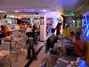 Electra walks through the restaurant preparing desserts at Los Robots in Medellin