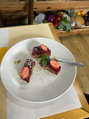 Exquisitely plated cake topped with fruit and mint and the coconut she hand-grated onto it.  at Happy Belly / Eat Smart in Tirana