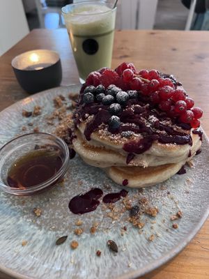 pancakes with berries, granola & maple syrup and matcha latte with almond milk  at Emmi's Kitchen - Glockenbach in Munich