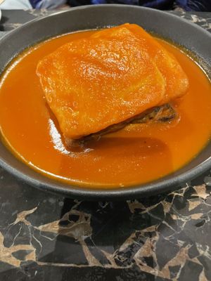 Portuguese speciality of bread and meat with a cheese and tomato sauce   at 26 Vegan Food Project in Lisbon