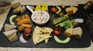 Cheese board with many different kinds of vegan cheeses, and at least 4 kinds of different delicious breads. Paradise. at 26 Vegan Food Project in Lisbon