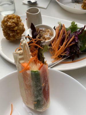 Entree of stuffed rice paper roll, with one bite - awesome! Corn fritters in background tasty, tasty, tasty  at Kindness Vegan in Darlinghurst