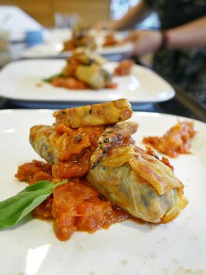 blueberry rice filled cabbage in tomato sugo and roasted sesame tempeh at Vegan Supper Club Bangkok in Bangkok