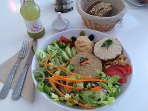 The "assiette vegan" with a variety of items, including a veggie burger (without bun), quinoa, salad and hummus. at Sweet Rawmance in Paris