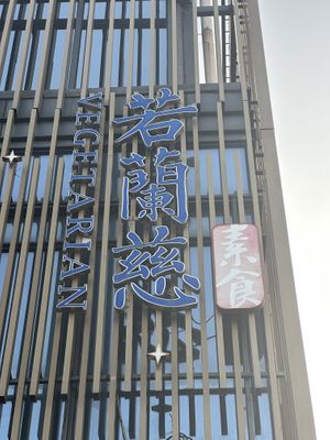 Restaurant name advertised on building  visible from street  at Ruolanci Vegetarian 若蘭慈素食馆(欢乐海岸店) in Shenzhen