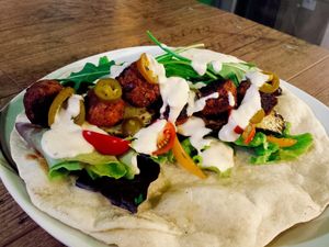 Hausgemachter Wrap mit gerösteten Zucchini, Paprika, Salat, Rucola, Jalapenos, veganen Bohnenbällchen at Veggieman Xpress in Nuremberg