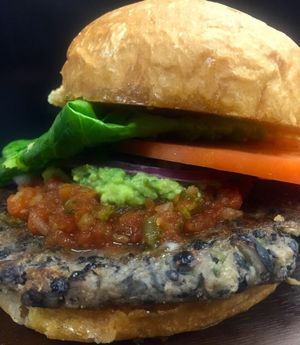 Garden Earth Burger.  Lentils, hemp, chia, pumpkin seeds, grains, veggies, spice. topped with house made salsa, guacamole, romaine and tomato on a brioche bun.  at Guernsey Kitchen in Cambridge