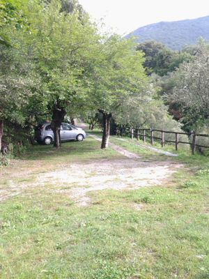 Parking space in front of the house with shadow of the trees at Due Di Moro in Gardone Riviera