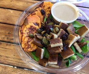 spinach salad with marinated seitan, cramalized onions, roasted sweet potato and a ginger tahini sauce at Natural Choice Cafe in Jerusalem