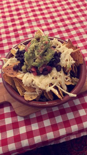 Vegan nachos with cheese and guacamole on top at Distrito Vegano in Madrid
