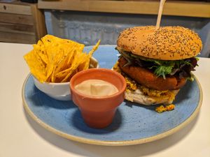 burger with chorizo patty and scrambled tofu, w/nachos and mustard sauce at Distrito Vegano in Madrid