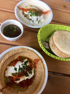 hummus with sun-dried tomatoes, hummus with fava beans, pita bread, garlic dip at Hummus & Friends in Berlin