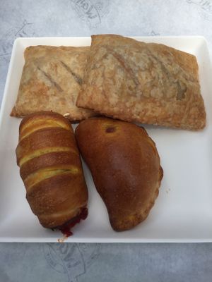 Savoury choices: two puff pastries filled with tomatoes and onions, vegan hotdog, vegan panzerotto at Wani Vegan Bakery in Rome